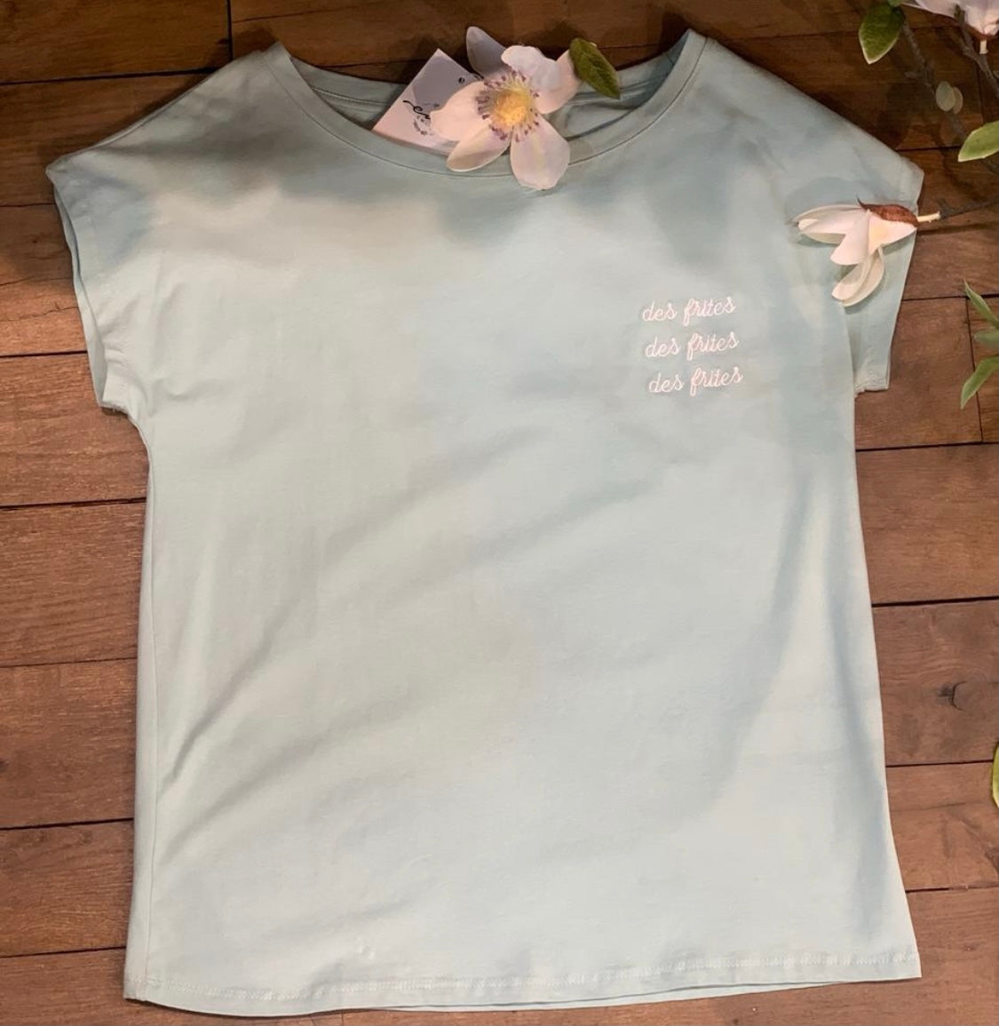 Tee-shirt turquoise comprenant des inscriptions : des frites , des frites , des frites