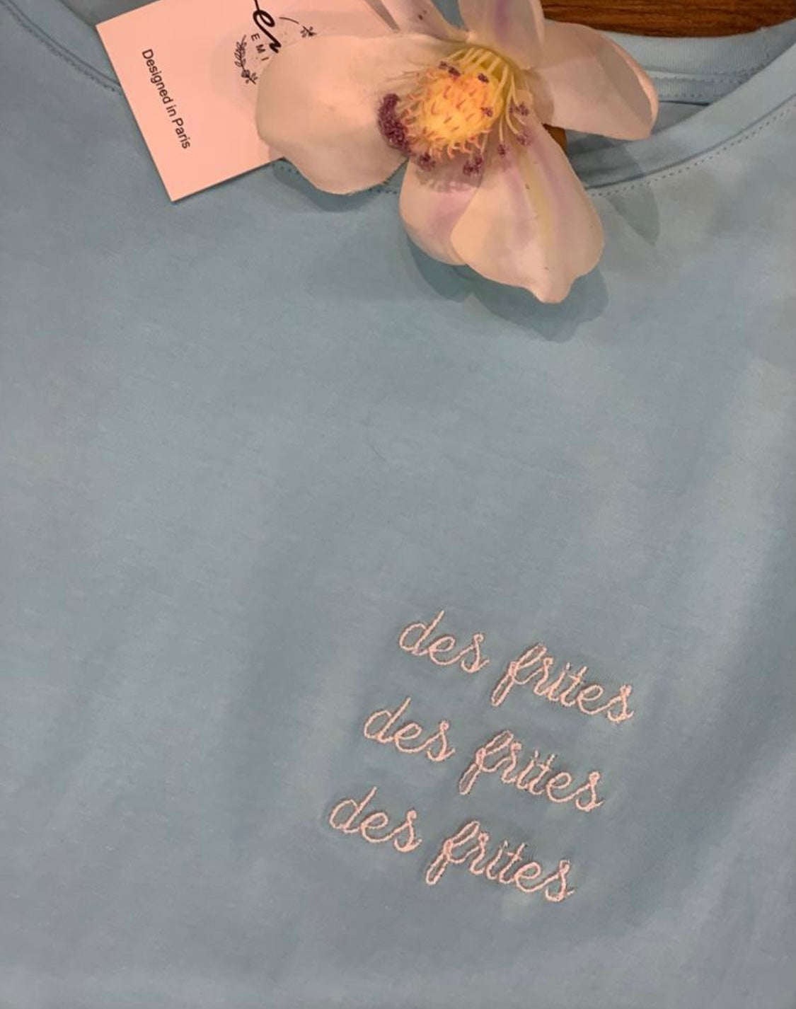 Tee-shirt turquoise comprenant des inscriptions : des frites , des frites , des frites